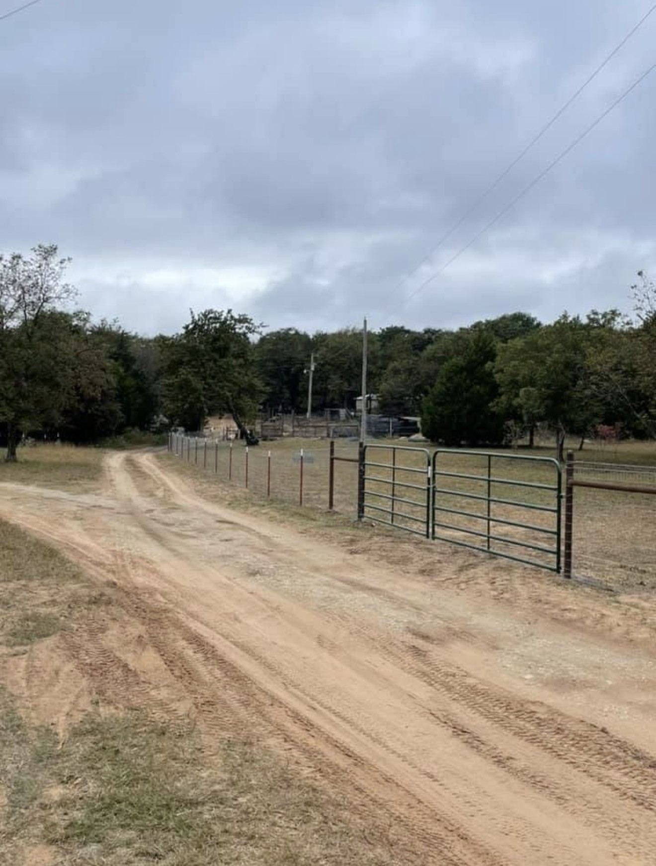 Steel pipe gate panels set beside a dirt drive
